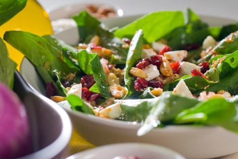 Plate of fresh colorfull spinach salad close up