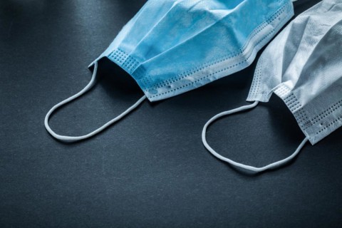 Disposable protective face mask on black background
