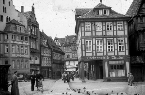 Historical image of 1930s of Town Square, Stadtplatz, people, bicycle, group of men, a store