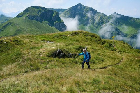 Hiker, senior climbs Saalkogel, behind Tristkogel and Gamshag, Kitzbühel Alps, Tyrol, Austria,