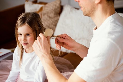 Father brushing his daughter s hair
