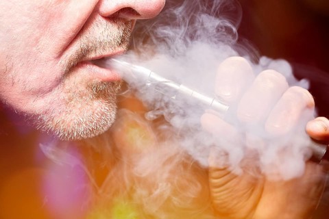 Close up portrait of a man smoking an e-cigarette