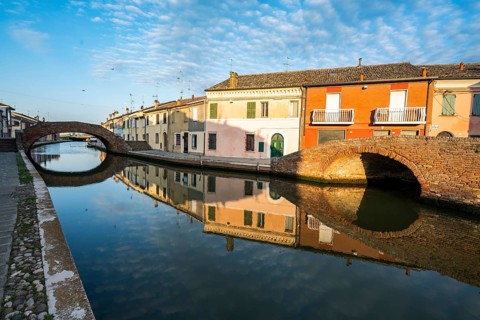 Houses and bridges reflected in the canal, Via Agatopisto Cromaciano, Comacchio, Emilia Romagna,