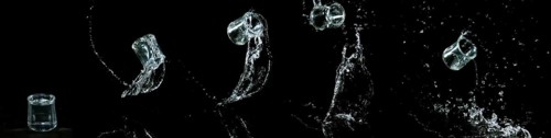 Glass of Water Bouncing and Splashing on Black Background