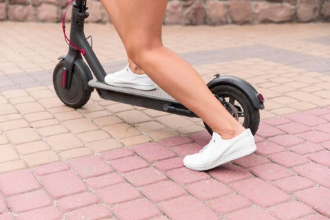 Woman using electric scooter outdoors