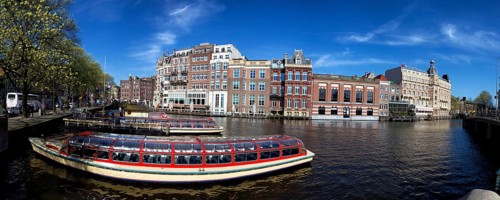 City tour ships are anchored at the Amstel in Amsterdam, Netherlands in spring. City tour ships