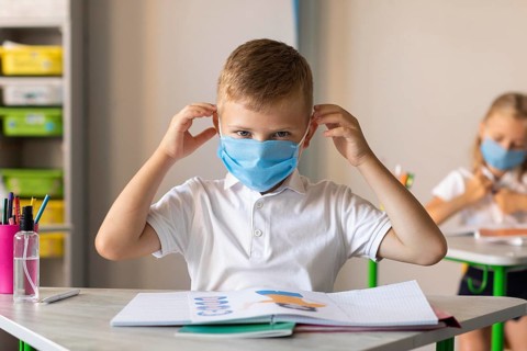 Little boy putting his medical mask