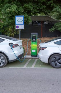 Moscenicka Draga, Croatia, August, 11, 2022 : Two white Tesla cars charging at EV charging station