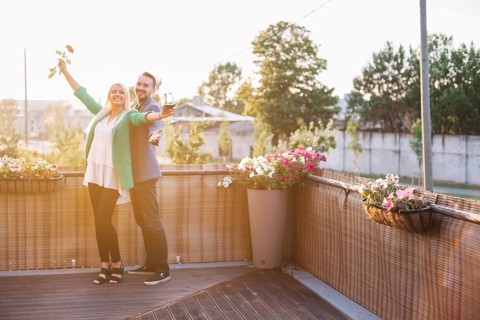 Portrait happy couple holding wineglass rose posing balcony