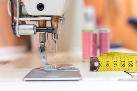 Close up of sewing metal sewing needle with sewing thread, tailor workshop