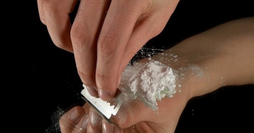 Hands of Woman and Drug against Black Background