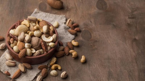 Bowl with nuts copy space wooden background