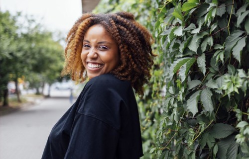 Close up photo of wavy hairdo charming cheerful dark skin person have good mood nice sightseeing