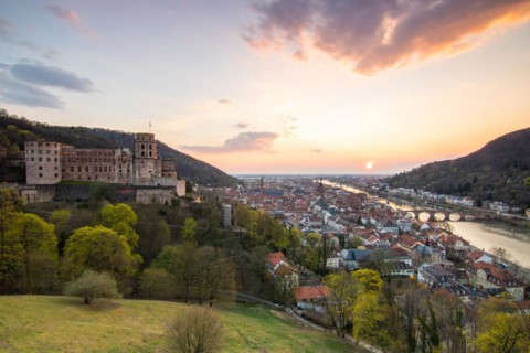 View over an old town with castle or palace rune in the evening at sunset. This town lies in a