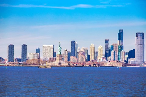 Statue of Liberty Statue of Liberty and behind it skyline of New Jersey City, seen from New York