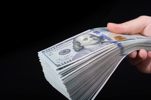 Hand holding American dollar banknotes isolated on white background