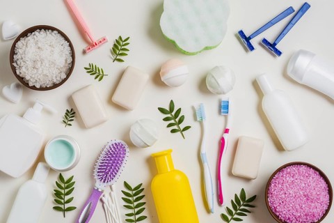 Cosmetic products with salt toothbrush razor hairbrush leaves white backdrop. Resolution and high