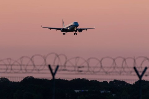 Passenger aircraft Embraer ERJ-190STD Cityhopper of the airline KLM in the sunset approaching