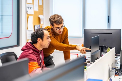 Team of engineers working with computer in a cnc modern factory office