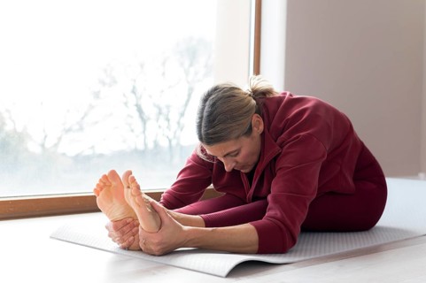 Mature woman doing sport exercises her window