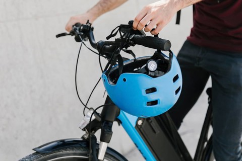 Close up bicyclist putting helmet bycicle handle