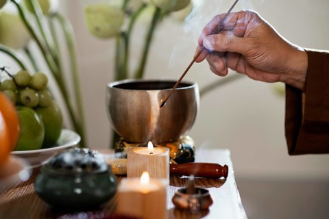 Side view man lighting incense stick. High resolution photo