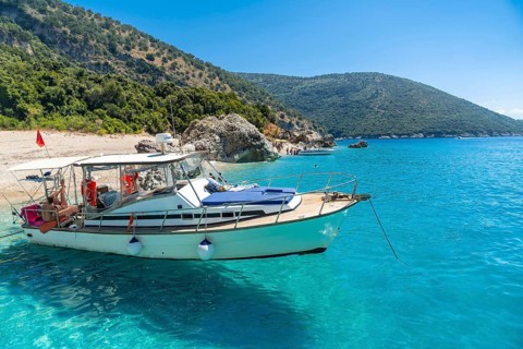 Boat in the transparent waters of the paradise beach of Kroreza or Krorez from the boat on the