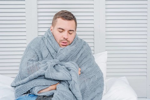 Young man wrapped warm scarf shivering from cold