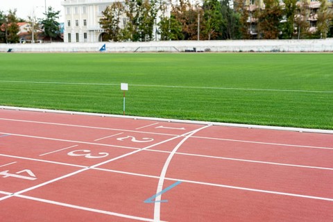 Running track with grass field sunny day