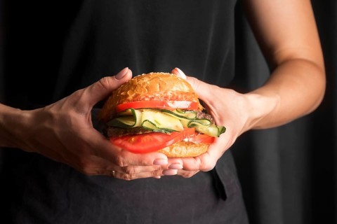 Man holding tasty hamburger