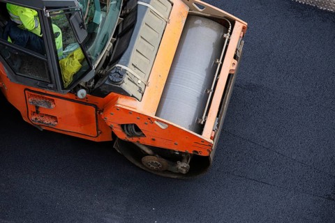 Road construction, asphalt roller press hot asphalt. Asphalt paving. High angle view