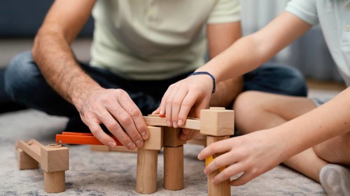 Father child playing with toys front view