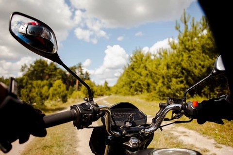 Biker riding motorbike dirt road