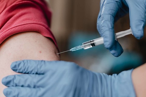 Doctor wearing gloves giving child vaccine