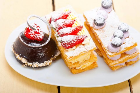 Selection of fresh cream napoleon and chocolate mousse cake dessert plate