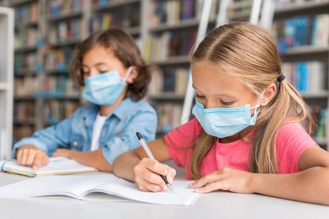 Kids doing homework while wearing face masks