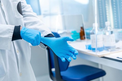 Close-up of a doctor using blue latex gloves in the laboratory of an hospital
