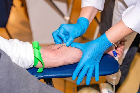 Close-up of an unrecognizable nurse puncturing the vein of a blood donor