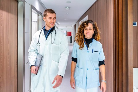 Smiling and relaxed health workers walking along a corridor of an hospital