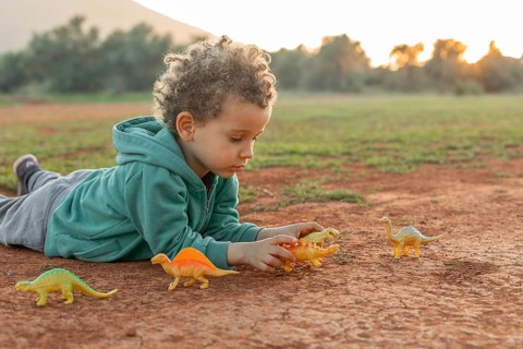 Little boy outdoors playing with toys