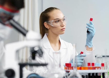 Female researcher laboratory with test tubes safety glasses male colleague
