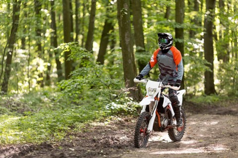 Active man riding motorcycle forrest