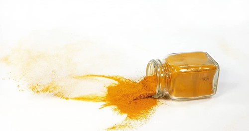 Turmeric (curcuma longa), Powder in a small Jar against White Background, Indian Spice