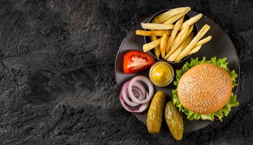 Top view burger fries plate with pickles copy space