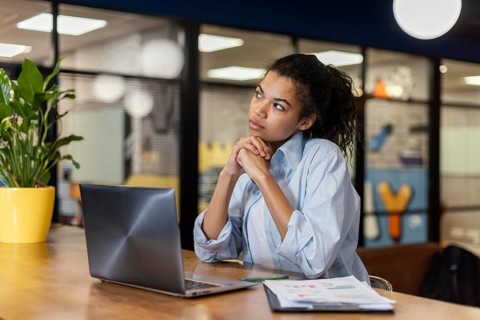 Pensive woman office with laptop