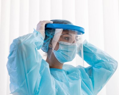 Side view woman doctor putting protective wear