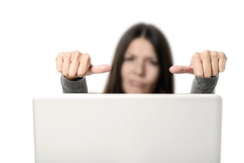 Unhappy Young Woman with Laptop Showing Thumbs on Sides Signs, Emphasizing Unsatisfactory.
