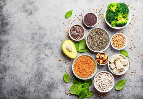 Variety of nutrient-rich food for vegans with copy space: beans, lentils, quinoa, tofu, vegetables,