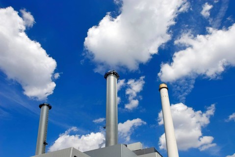 Heizkraftwerk Süd in Munich, a power plant with three chimneys, white clouds in blue sky seem to