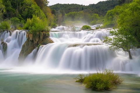 A quiet, gentle waterfall in the middle of a green, wooded landscape, Krka National Park, Krka